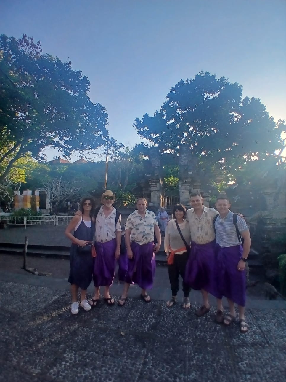 Sekelompok wisatawan mancanegara mengenakan sarung adat Bali saat mengunjungi destinasi wisata pura bersama Aruna Tour.