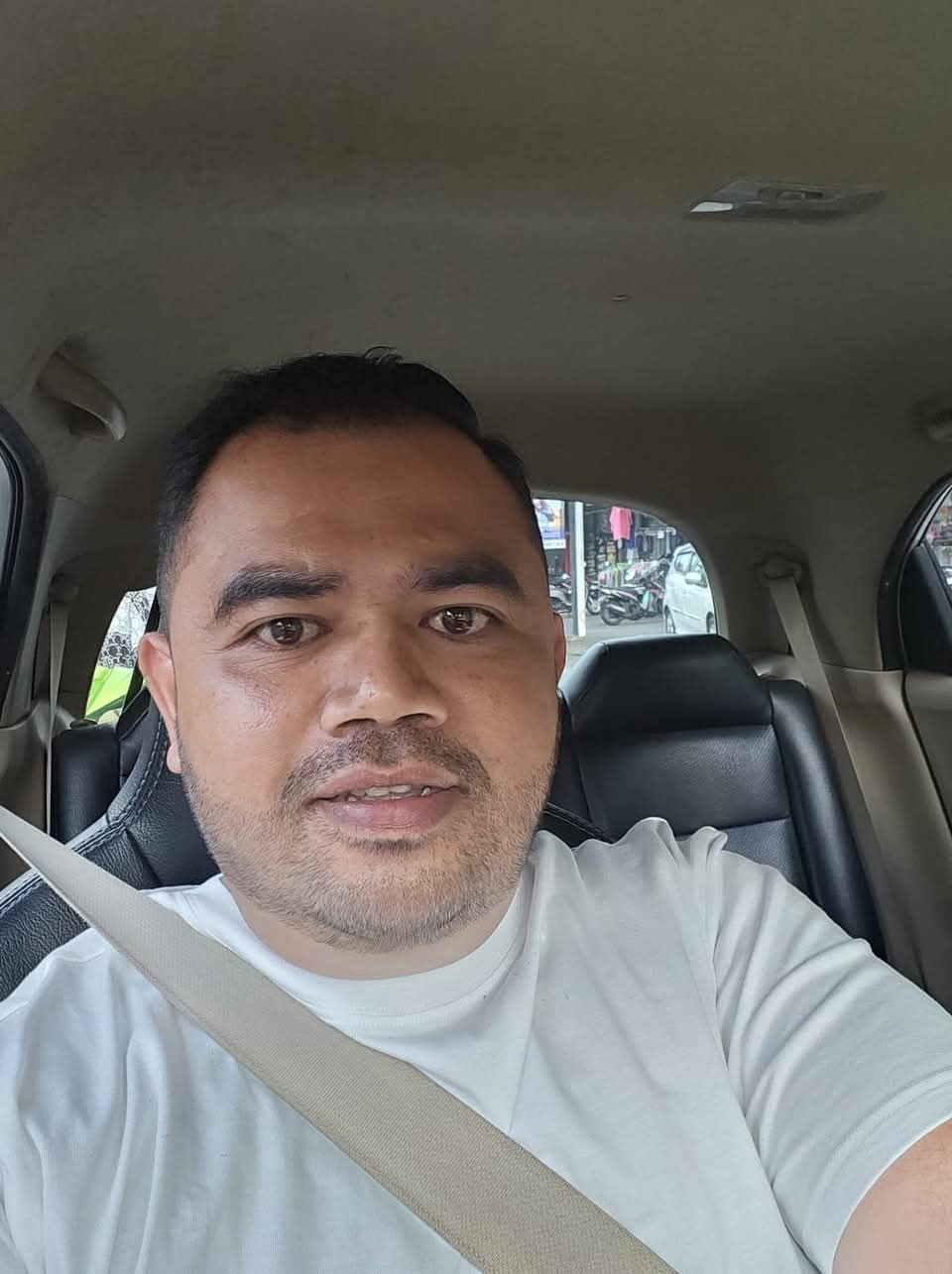 Foto Gusti Ngurah Putu Suryadi, Manager PT Duta Kencana Tour di dalam kendaraan jasa Bali Tour.
